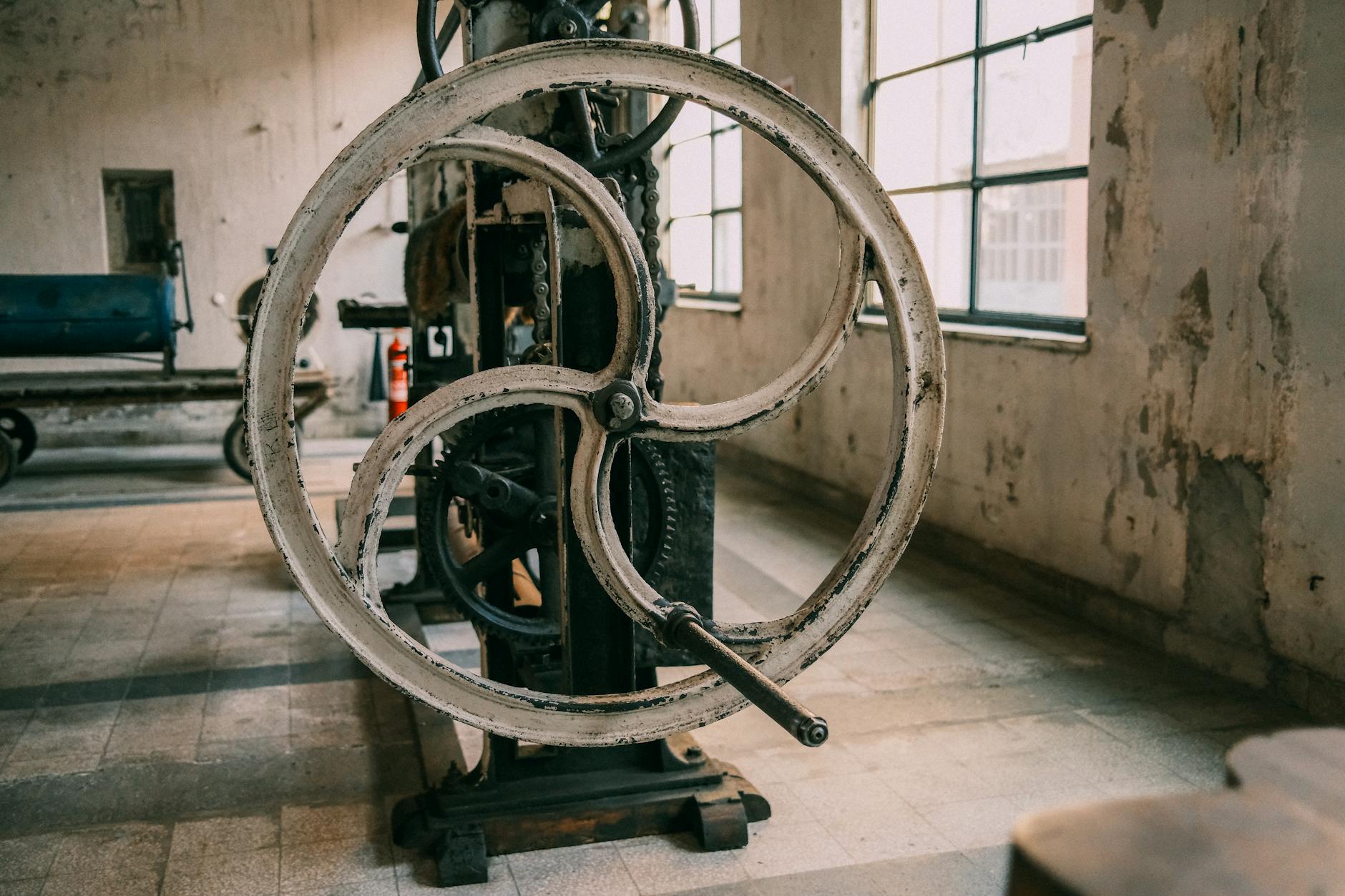 Close-up of a vintage industrial machine in an abandoned factory setting.
