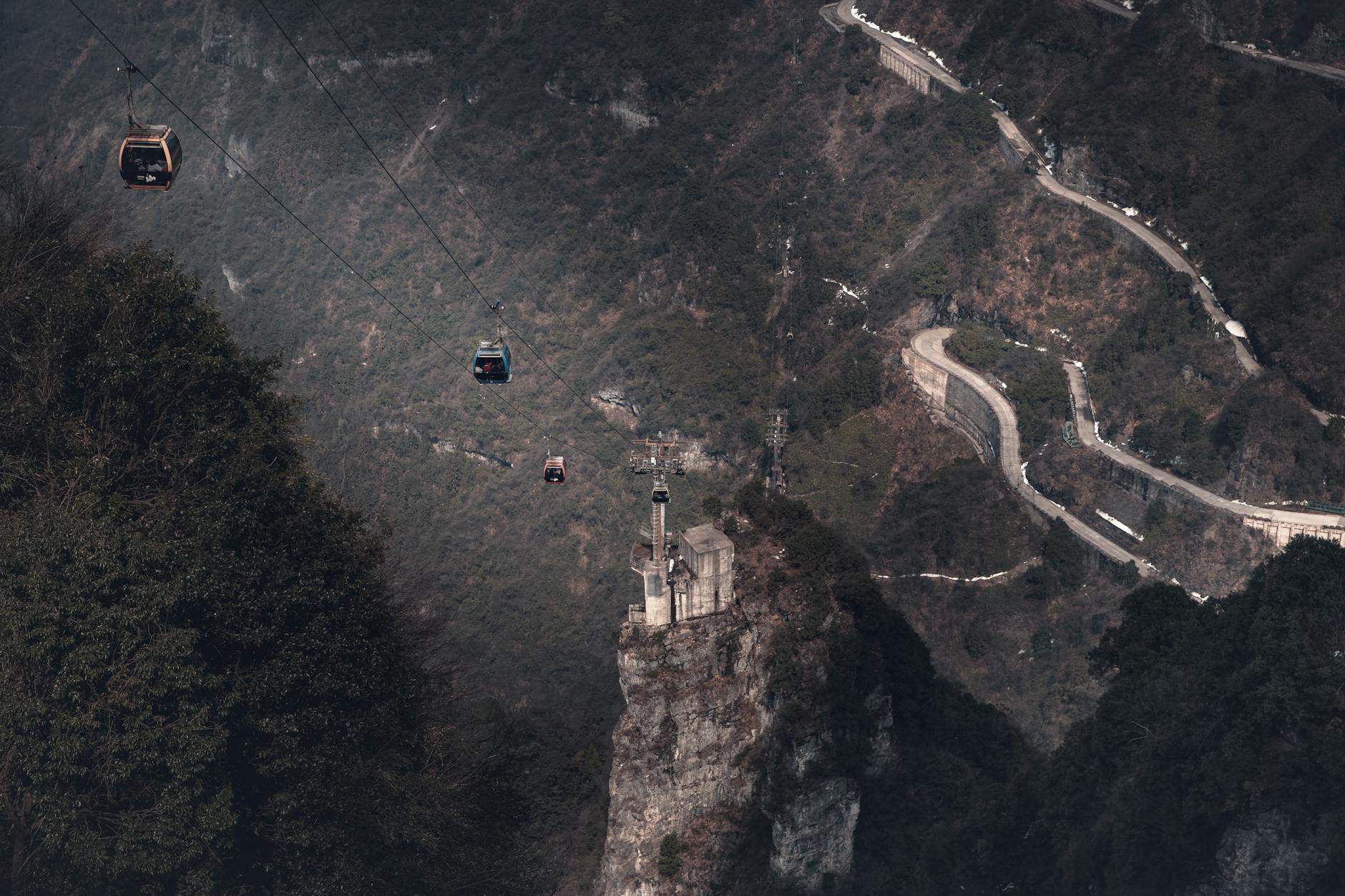 Cable cars traverse a dramatic mountain terrain in Zhangjiajie, showcasing a breathtaking natural landscape.