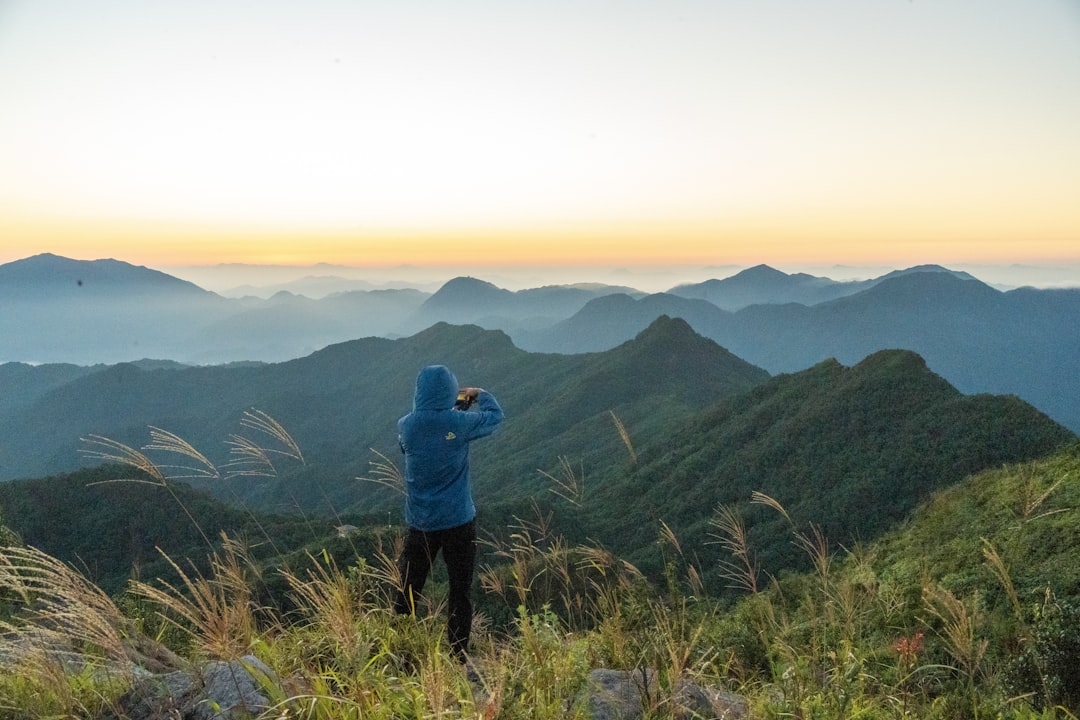 a person standing on a hill overlooking a valley with mountains in the background