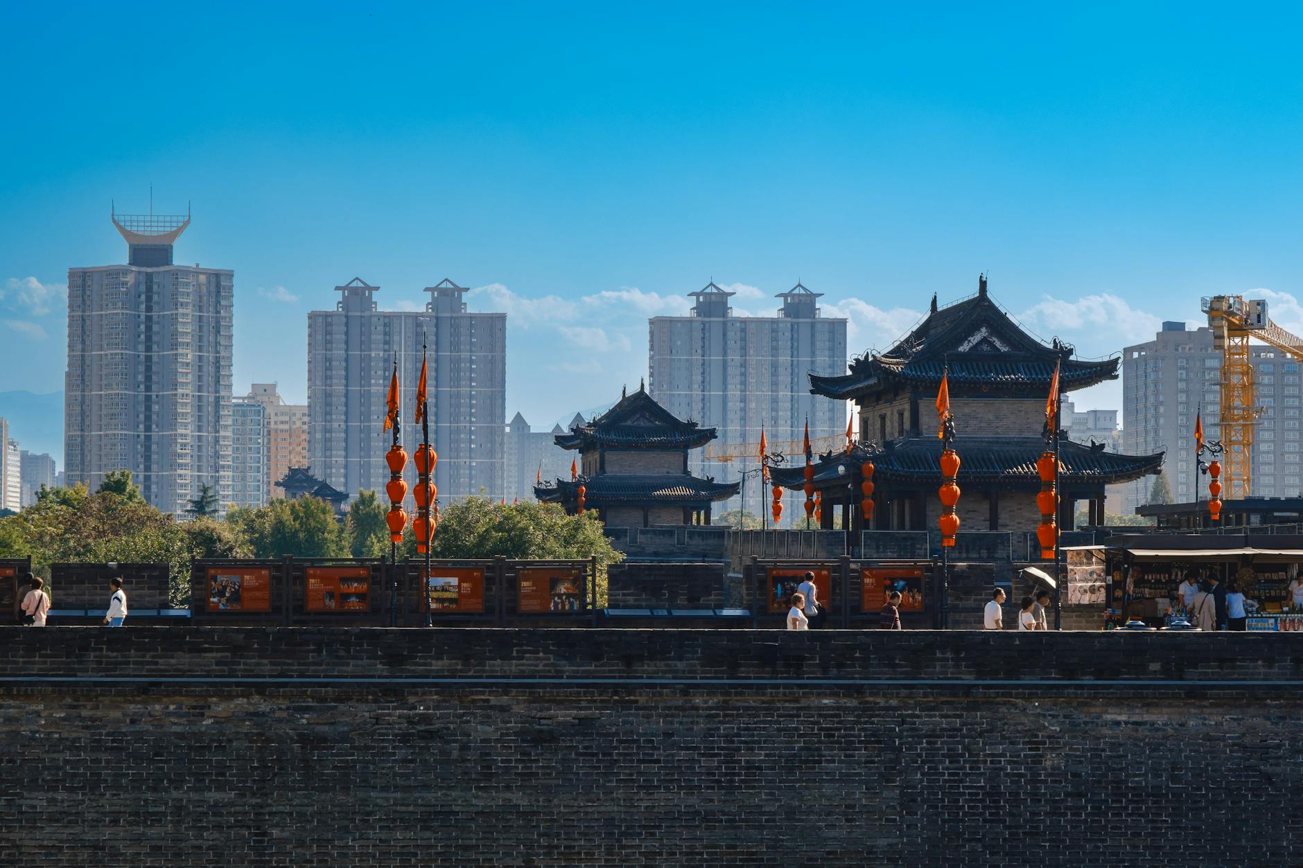 A cityscape blending traditional Chinese architecture with modern skyscrapers under a clear sky.