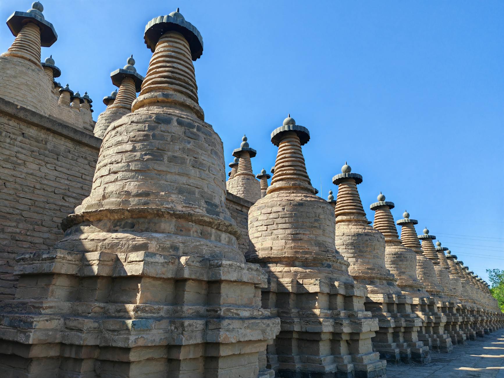 Rows of historic pagodas with distinct architecture under a clear blue sky, highlighting ancient design.