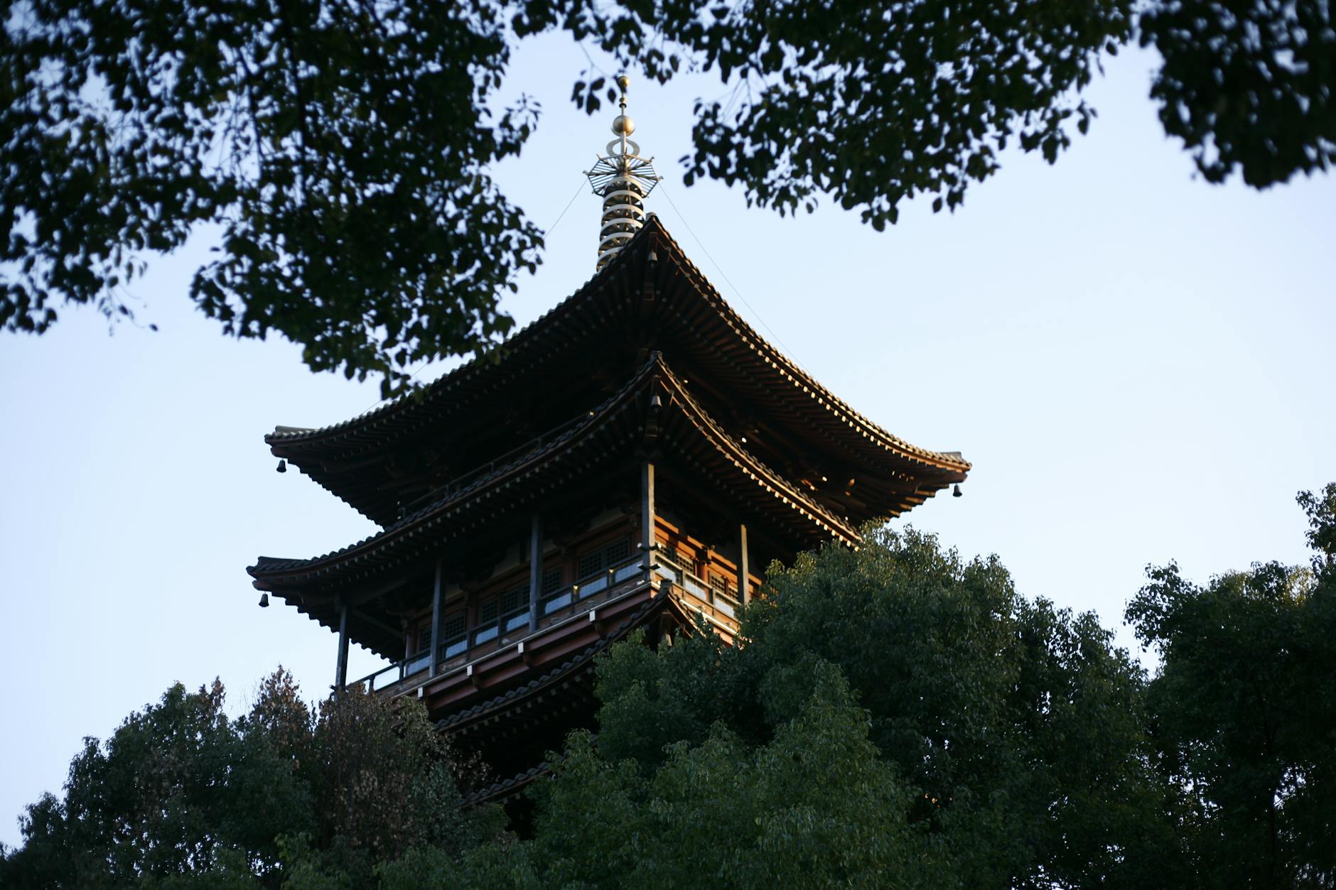 Captivating view of a traditional Chinese pagoda in Hangzhou, surrounded by lush greenery.