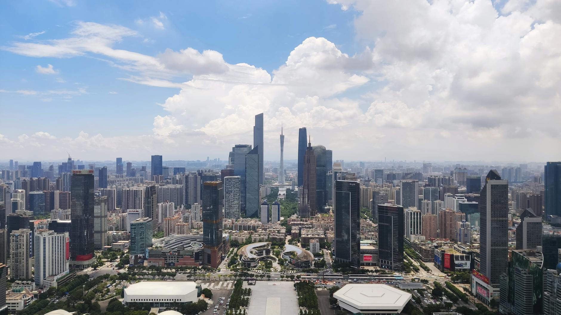 A stunning aerial view of Guangzhou's cityscape and skyscrapers under a blue sky.