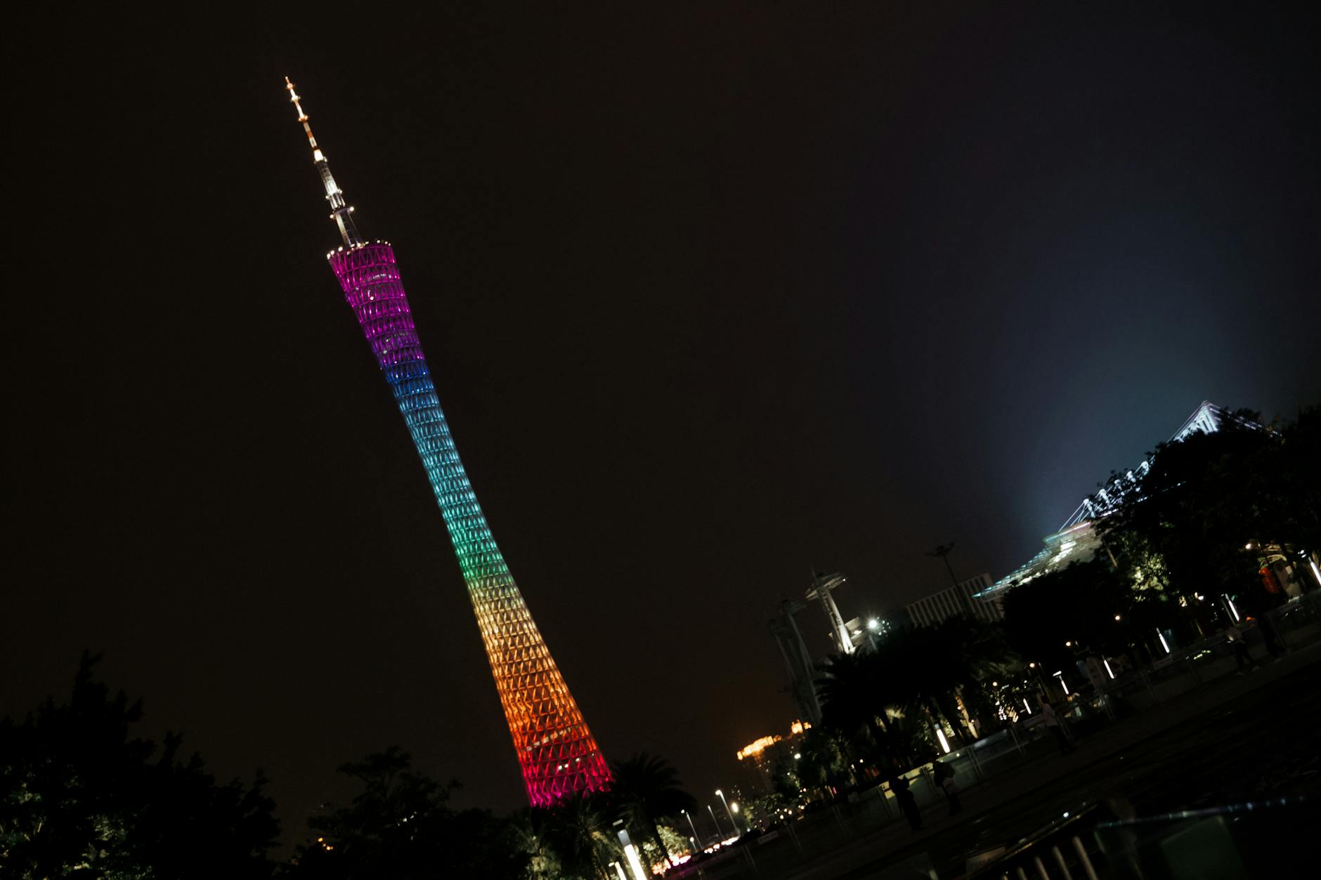 Vibrant night view of the illuminated Canton Tower in Guangzhou against a dark sky.