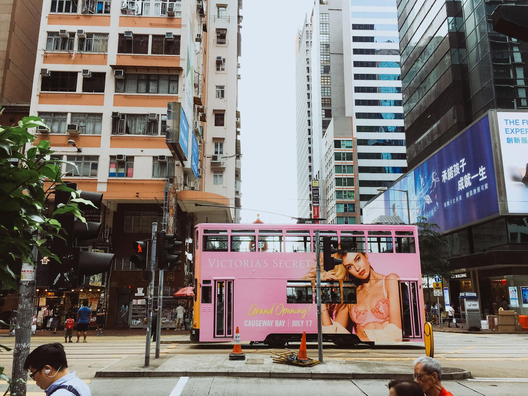 Colorful tram passes through Hong Kong Island's bustling business district.