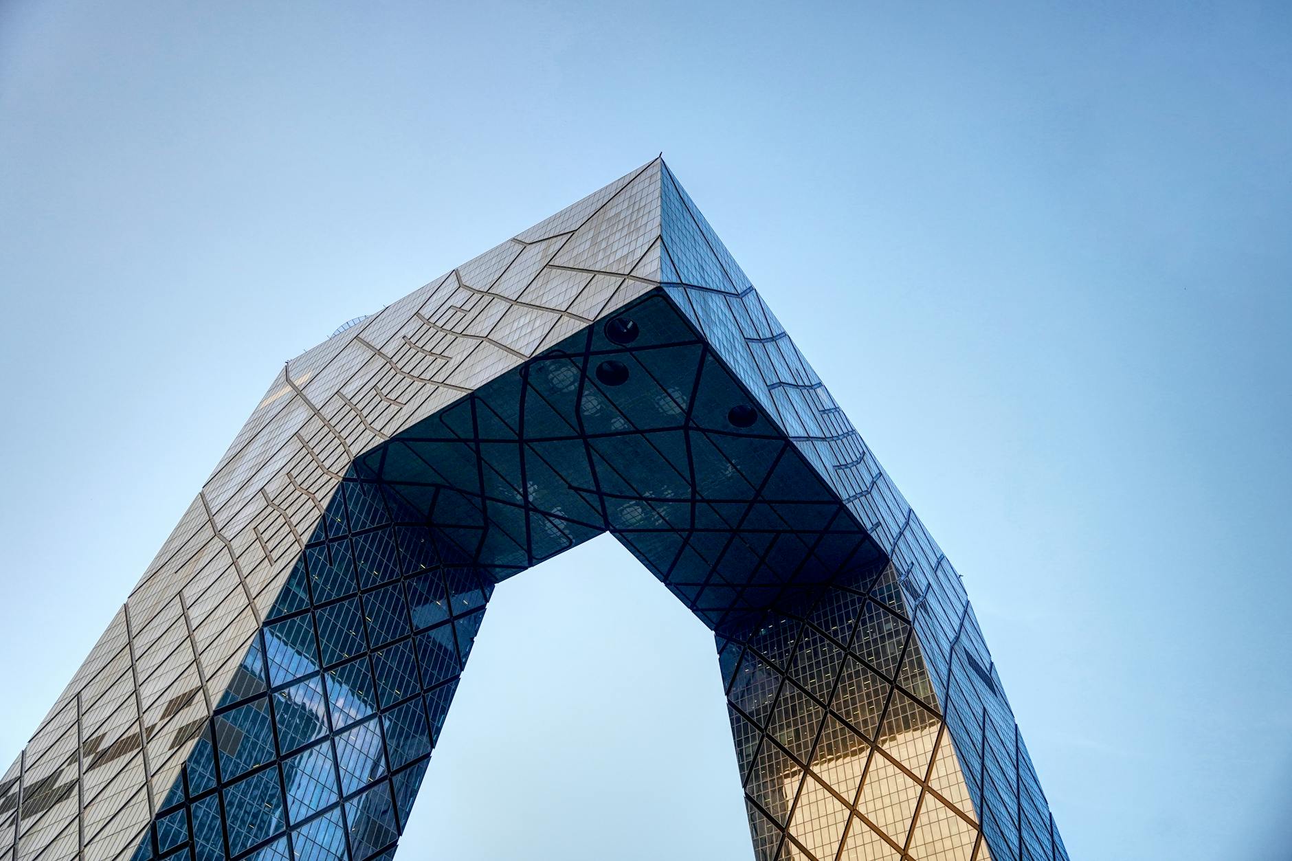 Low-angle view of the iconic CCTV Headquarters against a clear blue sky in Beijing.