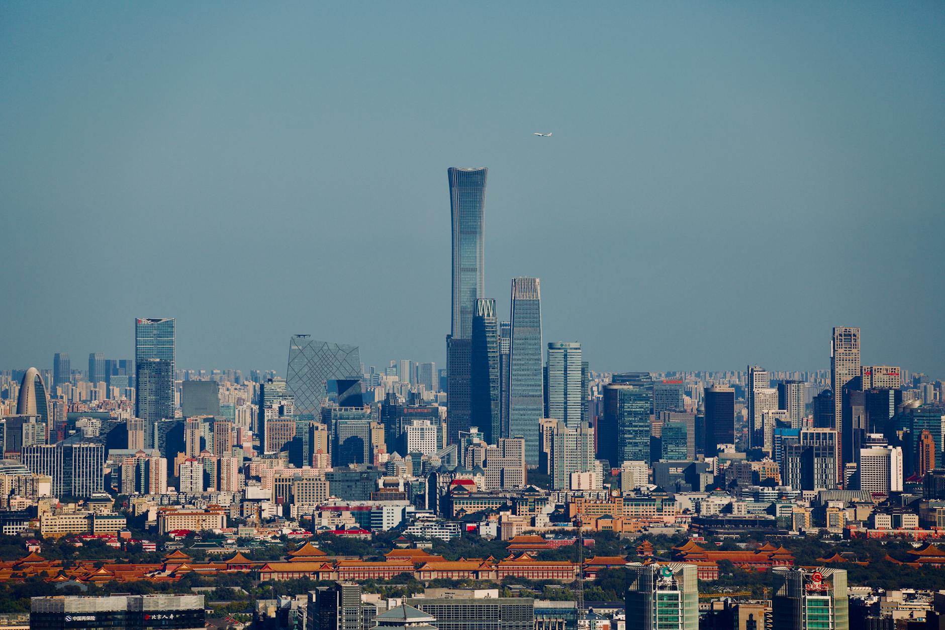 Aerial view of Beijing's skyline featuring modern skyscrapers against a clear blue sky.