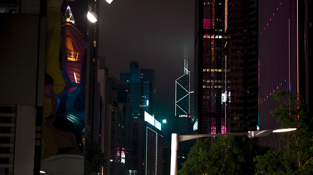 A city street at night with tall buildings