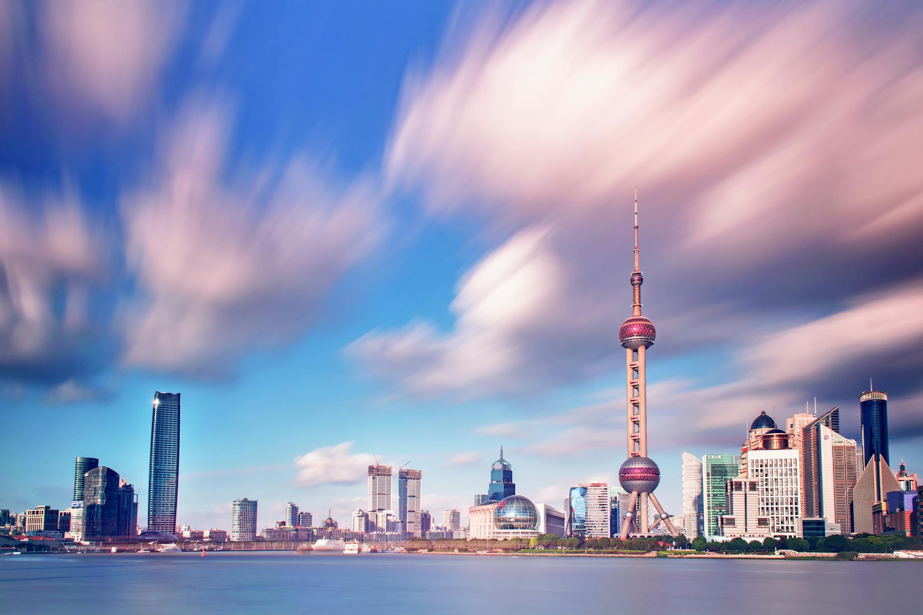 Stunning Shanghai skyline featuring the Oriental Pearl Tower with dramatic cloud movement.