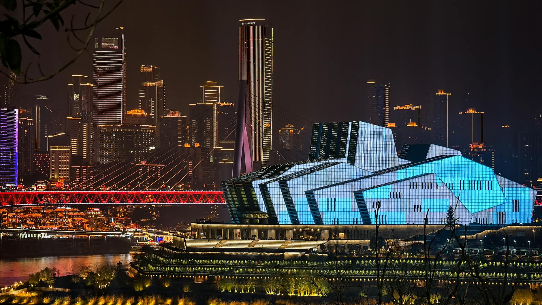 Vivid night scene of Chongqing featuring modern architecture and illuminated skyline.