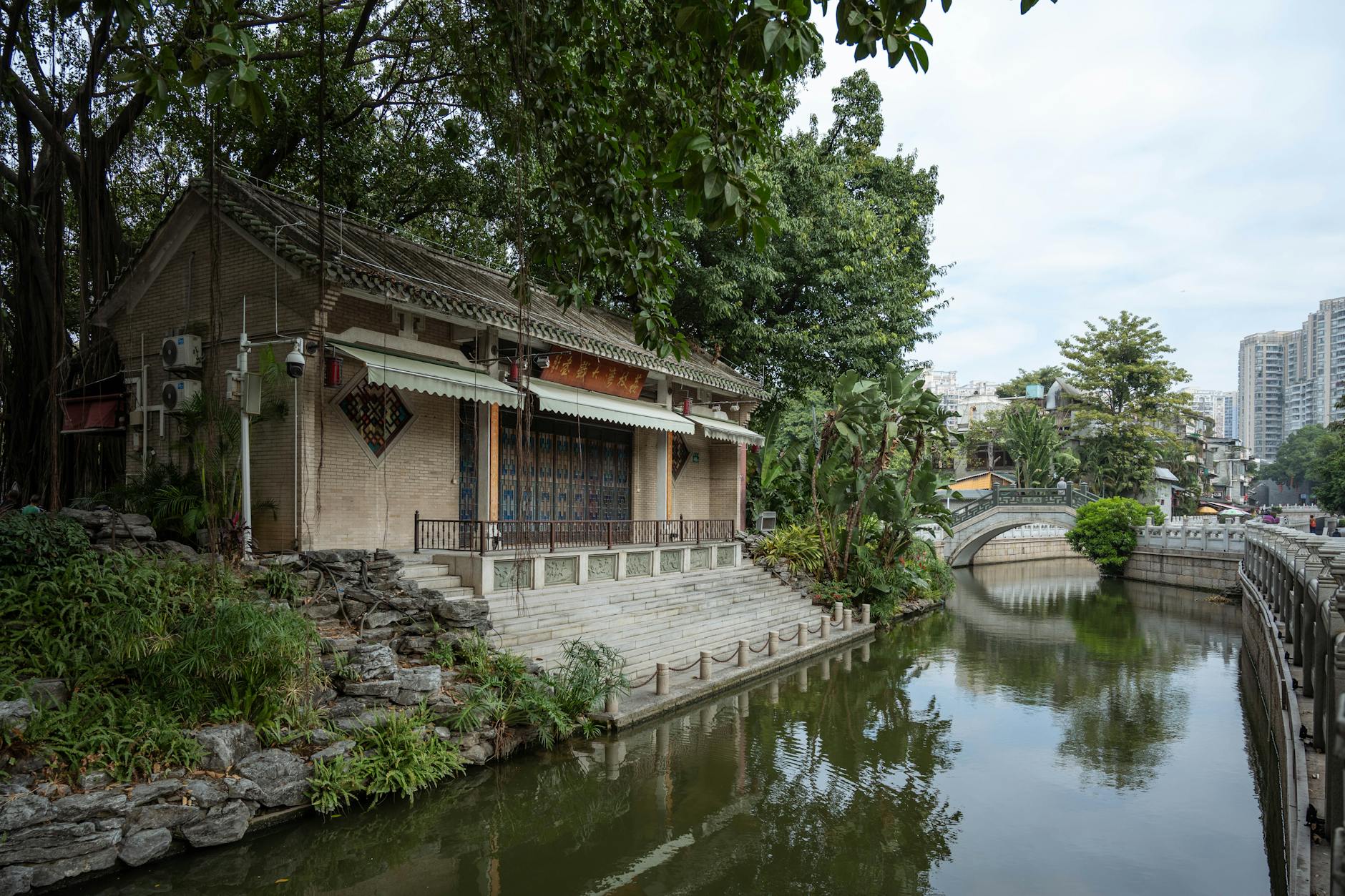Scenic view of historic architecture and serene river in Guangzhou, China.
