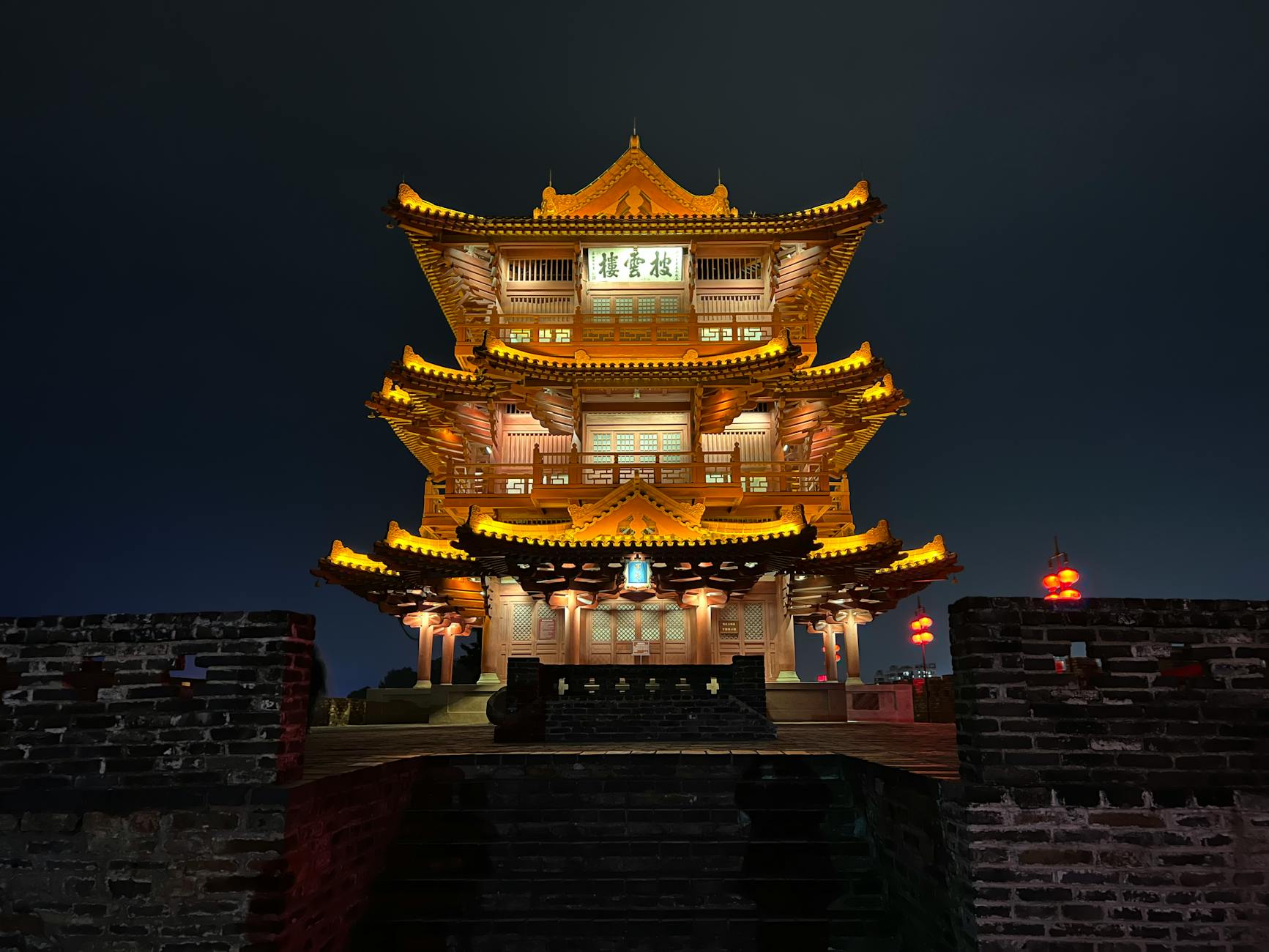 A beautifully lit traditional Chinese pagoda against a night sky.