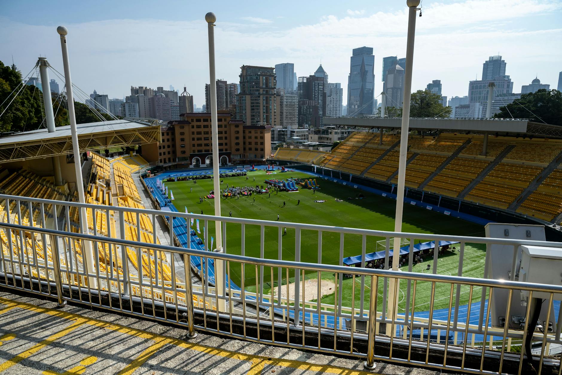 Wide-angle view of a Guangzhou sports stadium with city skyscrapers in the background.