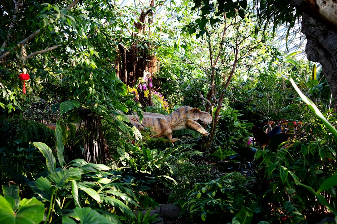 A dinosaur in the middle of a lush green forest