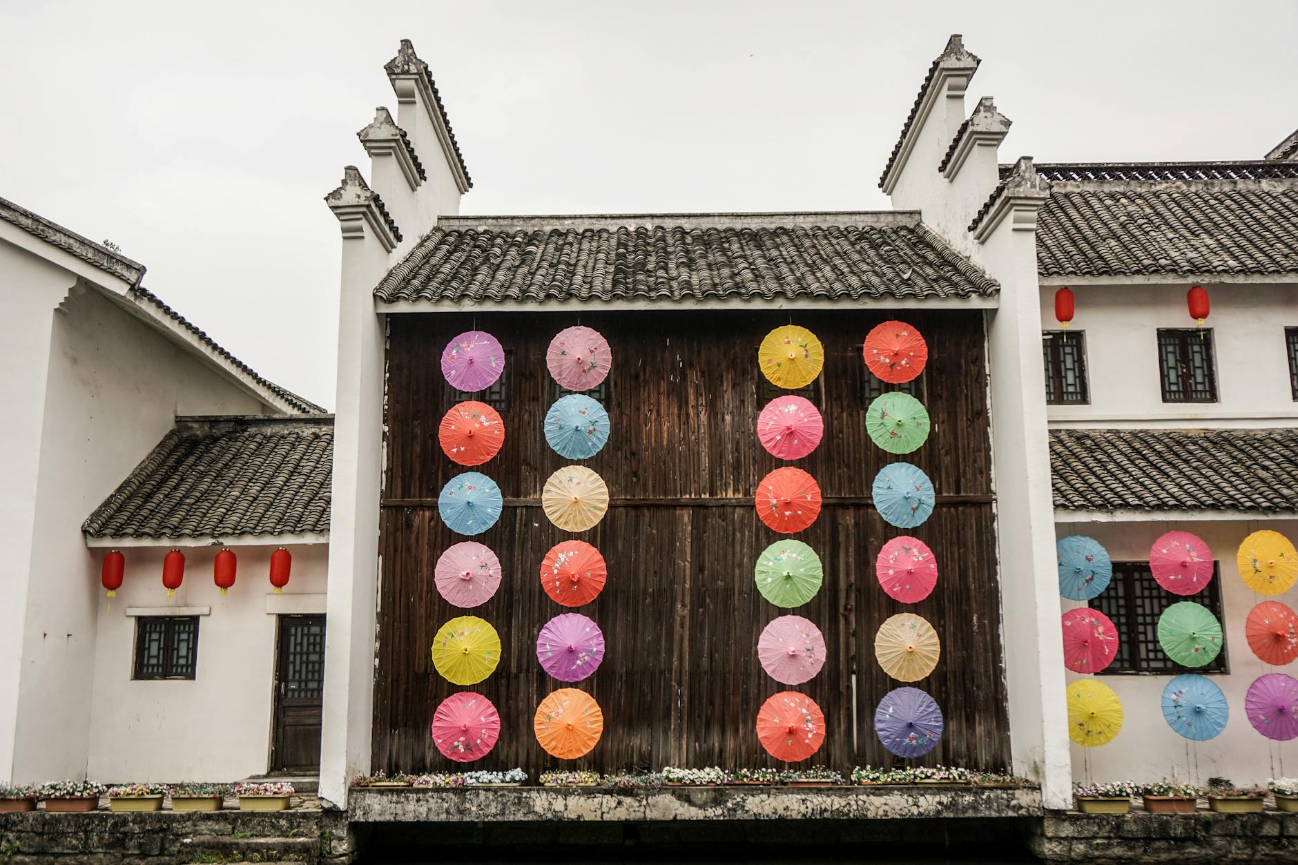 Vibrant umbrellas decorating a traditional Chinese building with classic architecture.