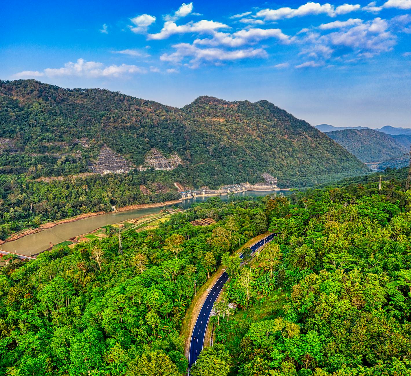 Stunning aerial view of lush green landscape with mountains and road in West Java, Indonesia.