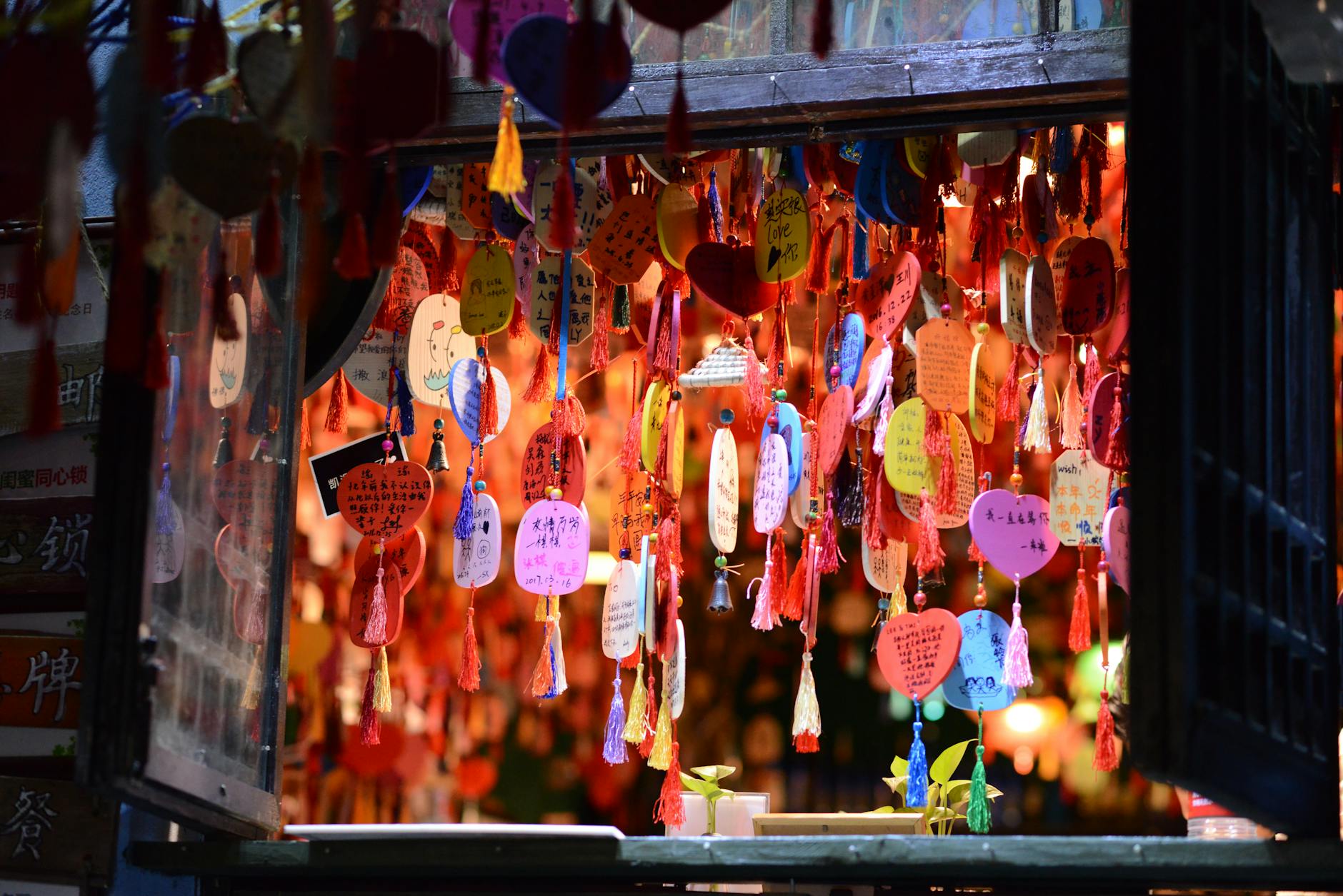 Vibrant display of heart-shaped wishes hanging at a Chongqing street market, China.