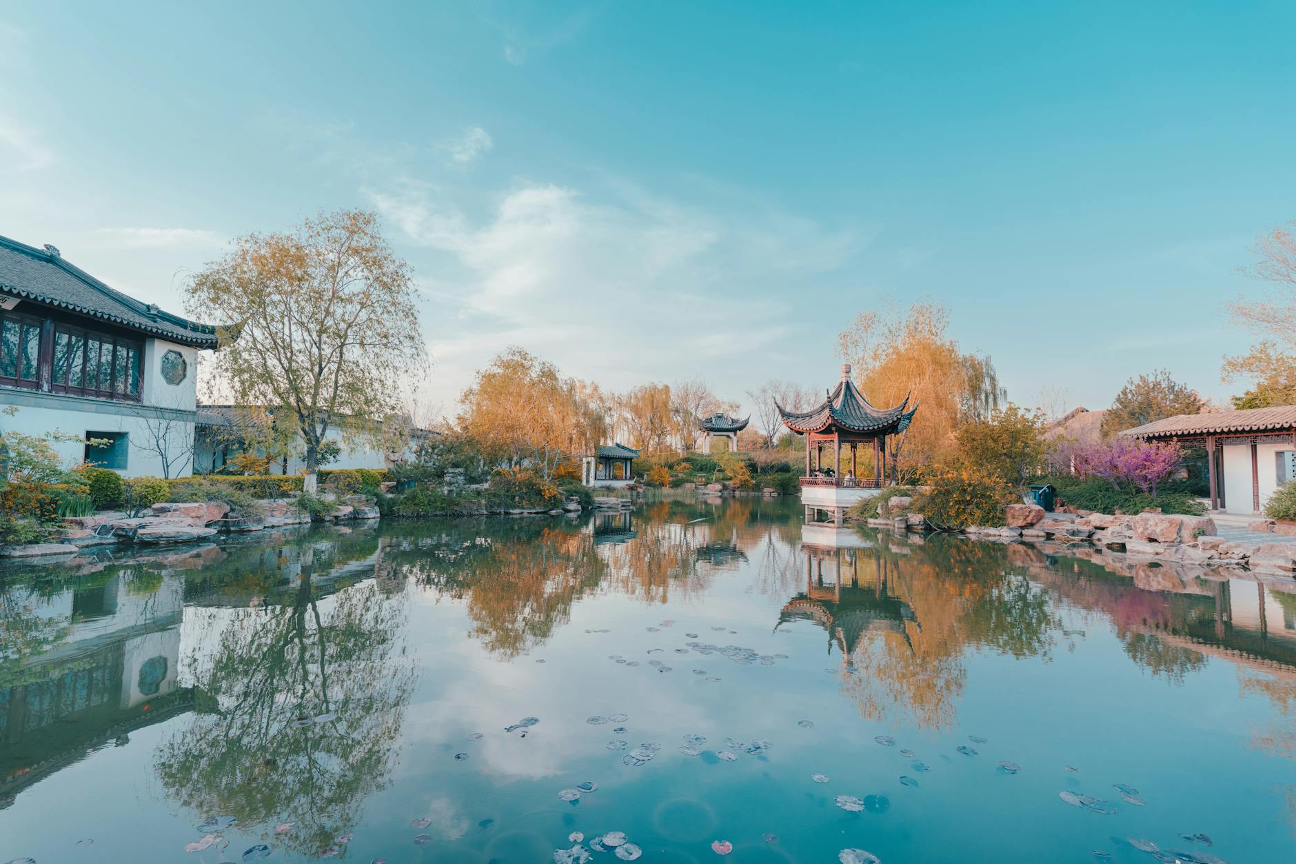 Beautiful autumn reflection of traditional Chinese pavilions in a serene garden pond in Suzhou.