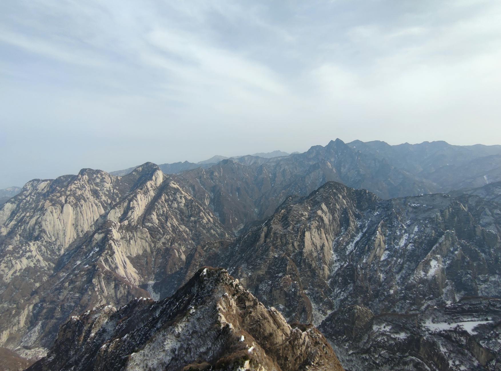 Breathtaking view of Huashan mountains showcasing rugged peaks and vast landscapes.