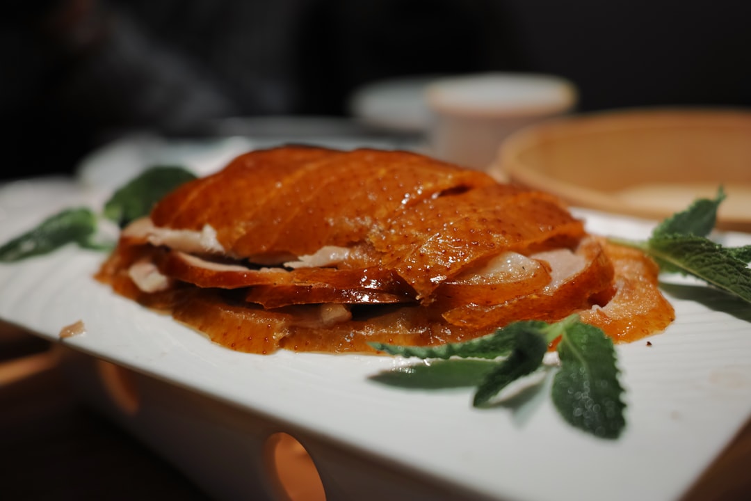 Crispy peking duck with mint leaves on white plate
