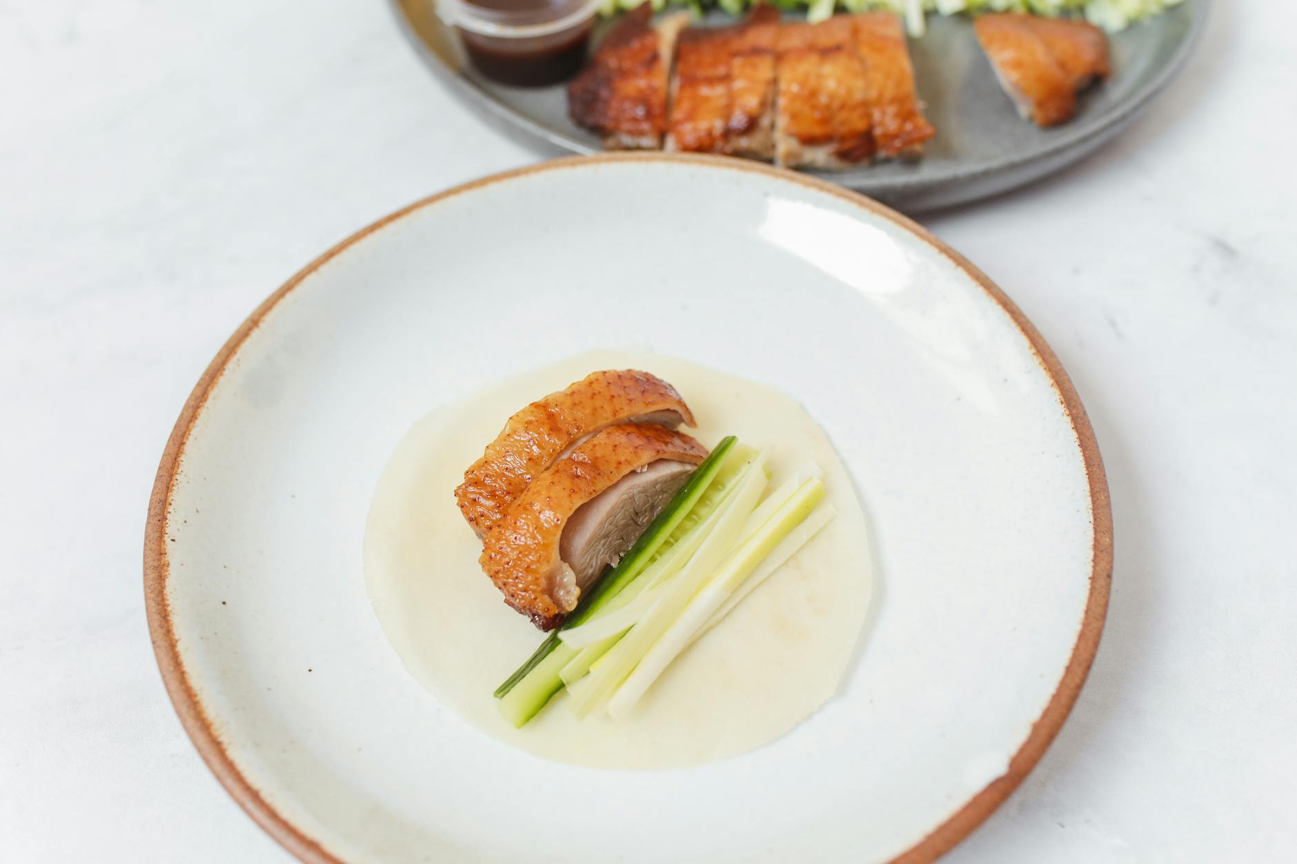 Enjoy a close-up of crispy Peking duck served with fresh vegetables, showcasing a delicious Asian culinary delight.