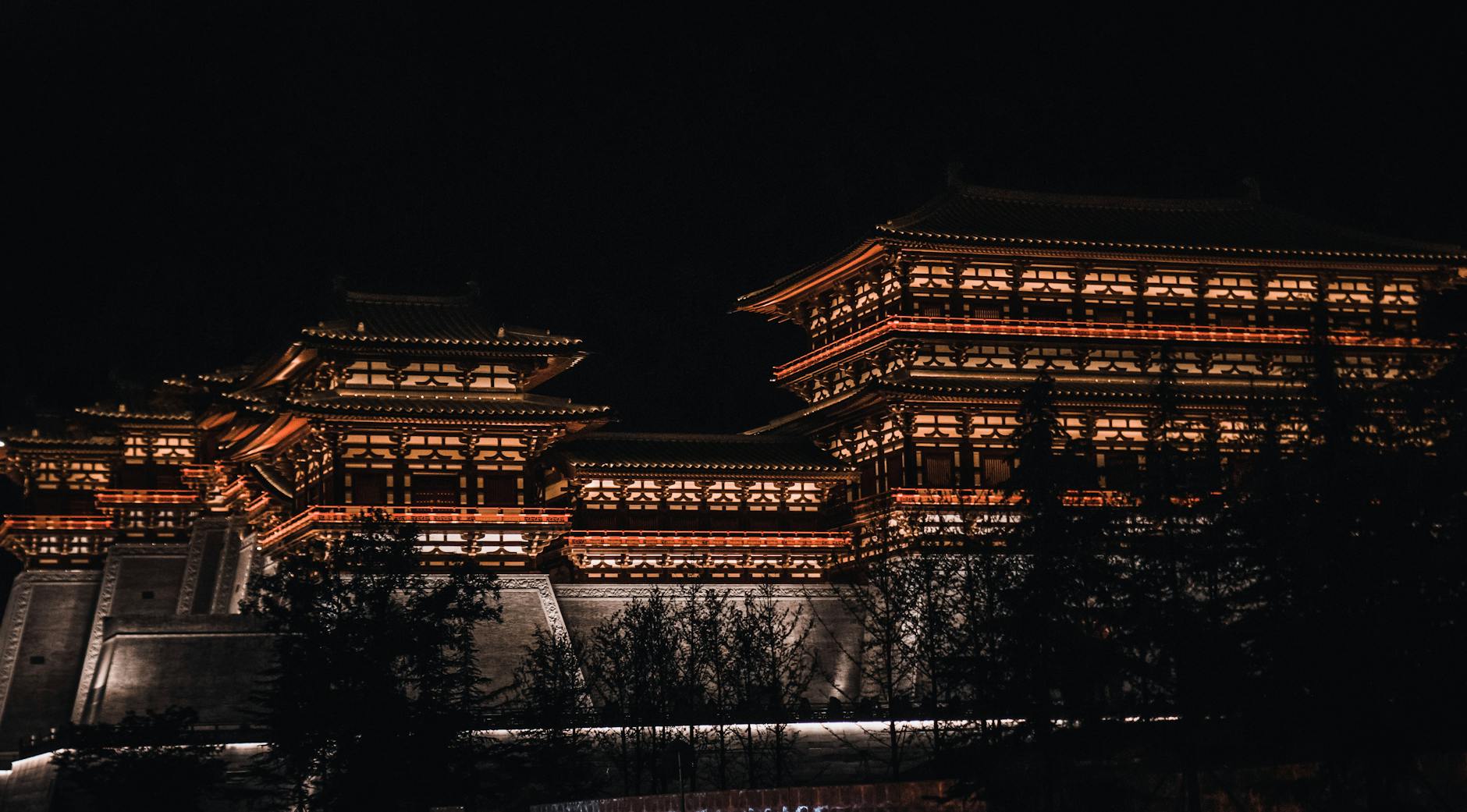 Stunning view of a traditional Chinese building illuminated at night, showcasing intricate architectural details.