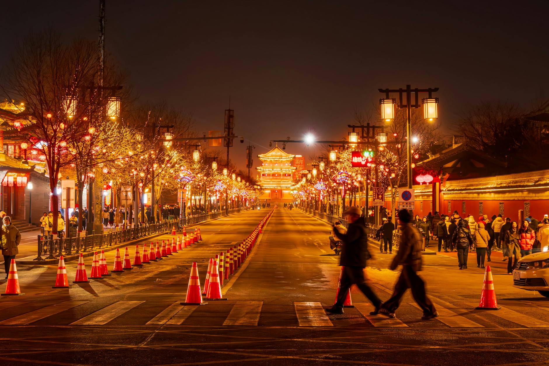 Captivating evening scene of illuminated street with crowds and classic architecture in Xi'an, China.