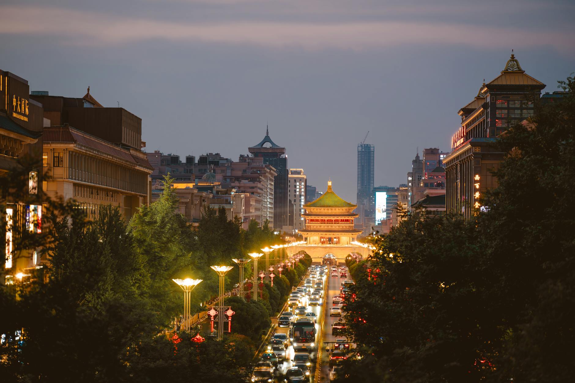 Scenic evening view of Xi'an Bell Tower with lively streets and illuminated architecture.