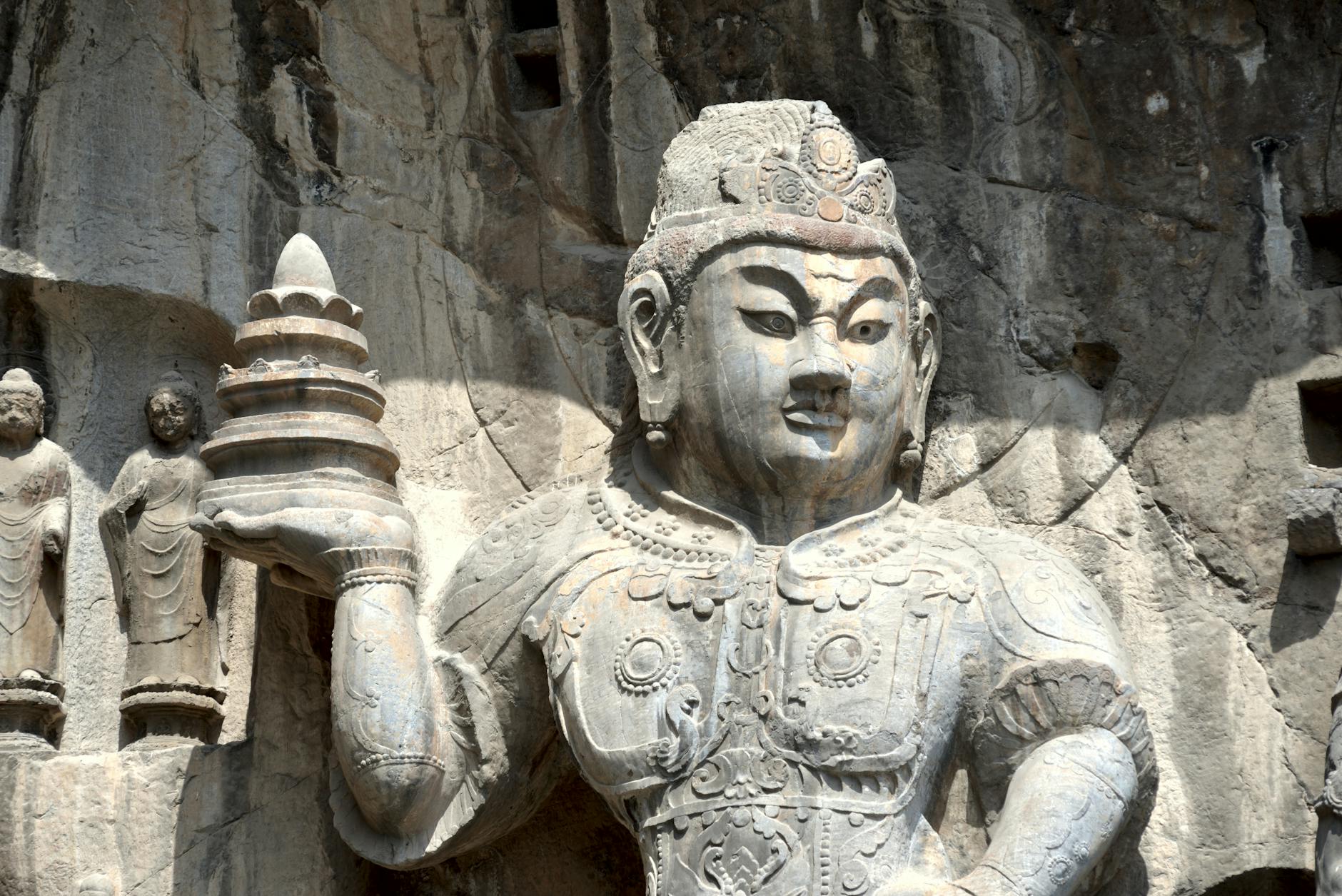 Intricate stone carving of a Buddha statue at a historic site, showcasing ancient artistry.