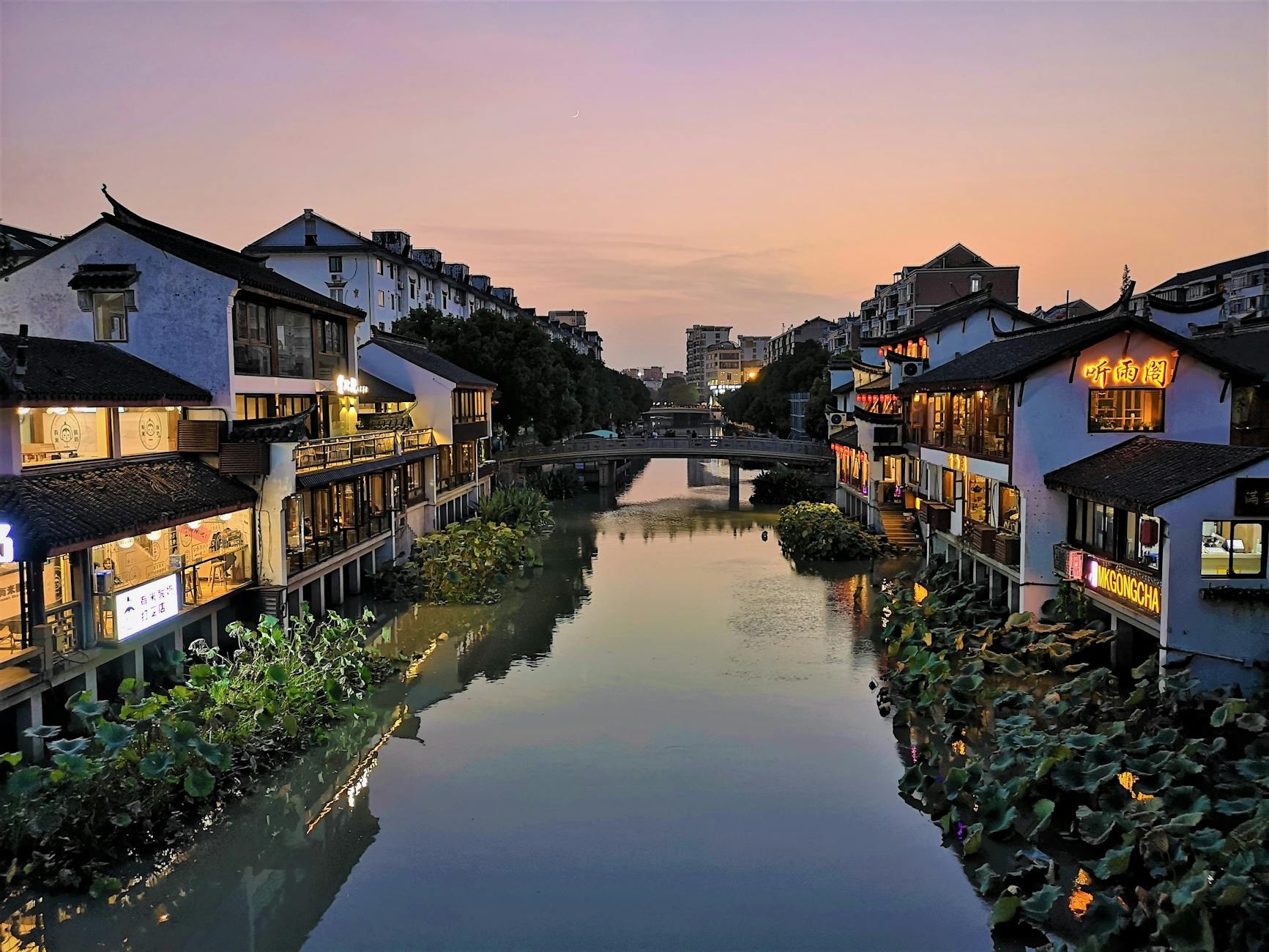 Serene twilight scene of a traditional water town in Shanghai with reflections in the canal.