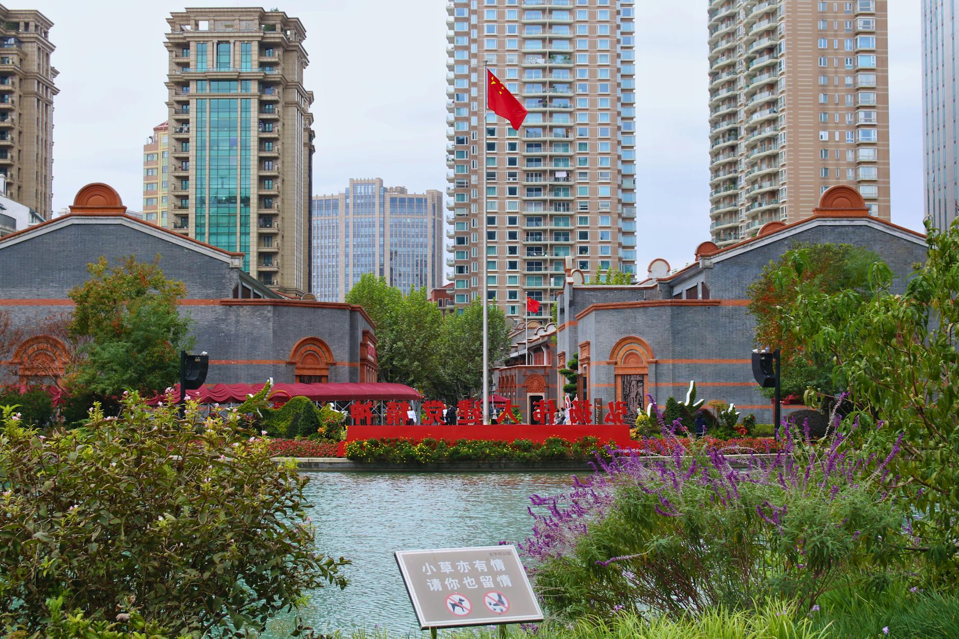 Vibrant urban scene in Shanghai featuring high-rises, historic buildings, and the Chinese flag.
