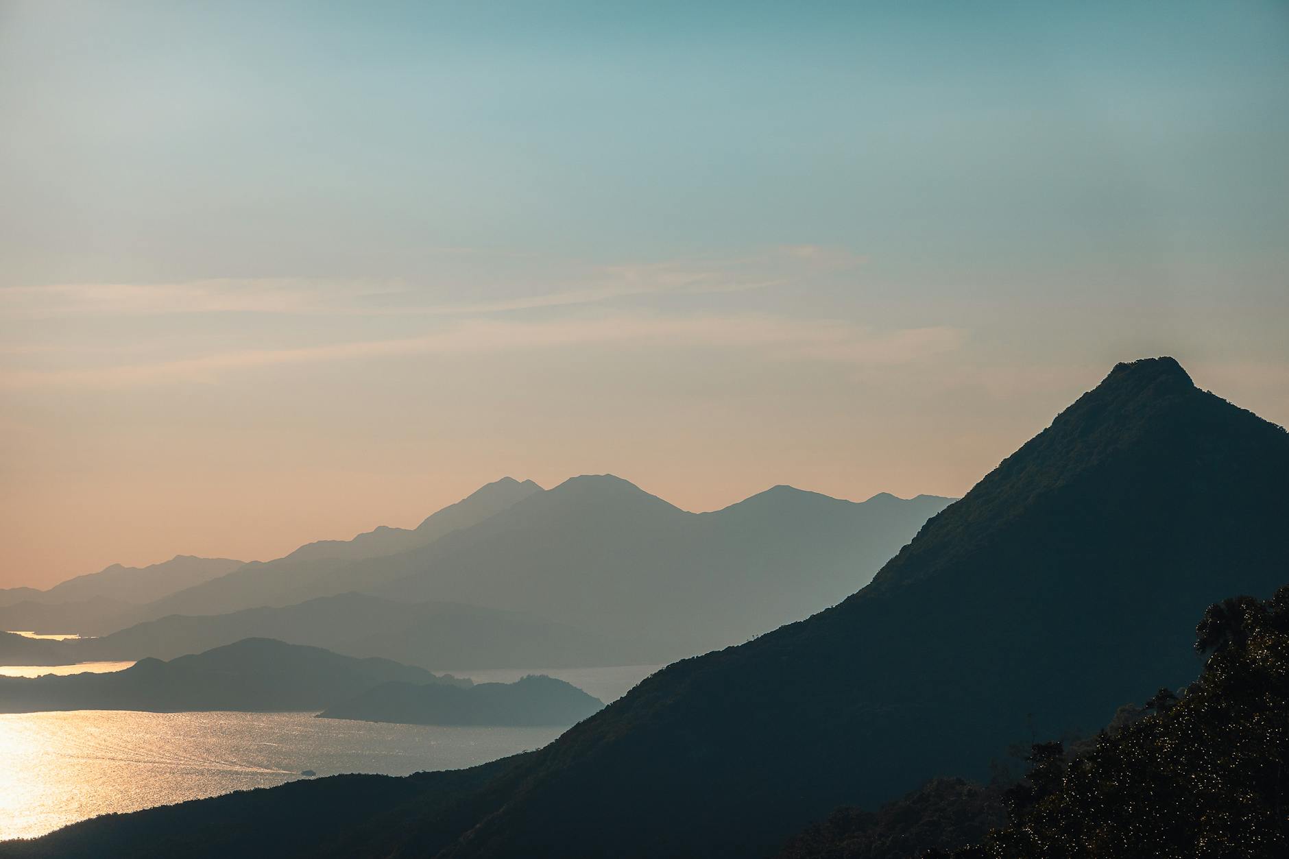 Serene mountain silhouette with sunset glow on Hong Kong Island, offering a tranquil natural view.