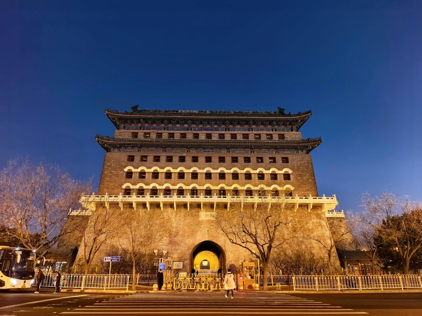 Zhengyangmen tower's historic architecture illuminated at twilight in Beijing, China.