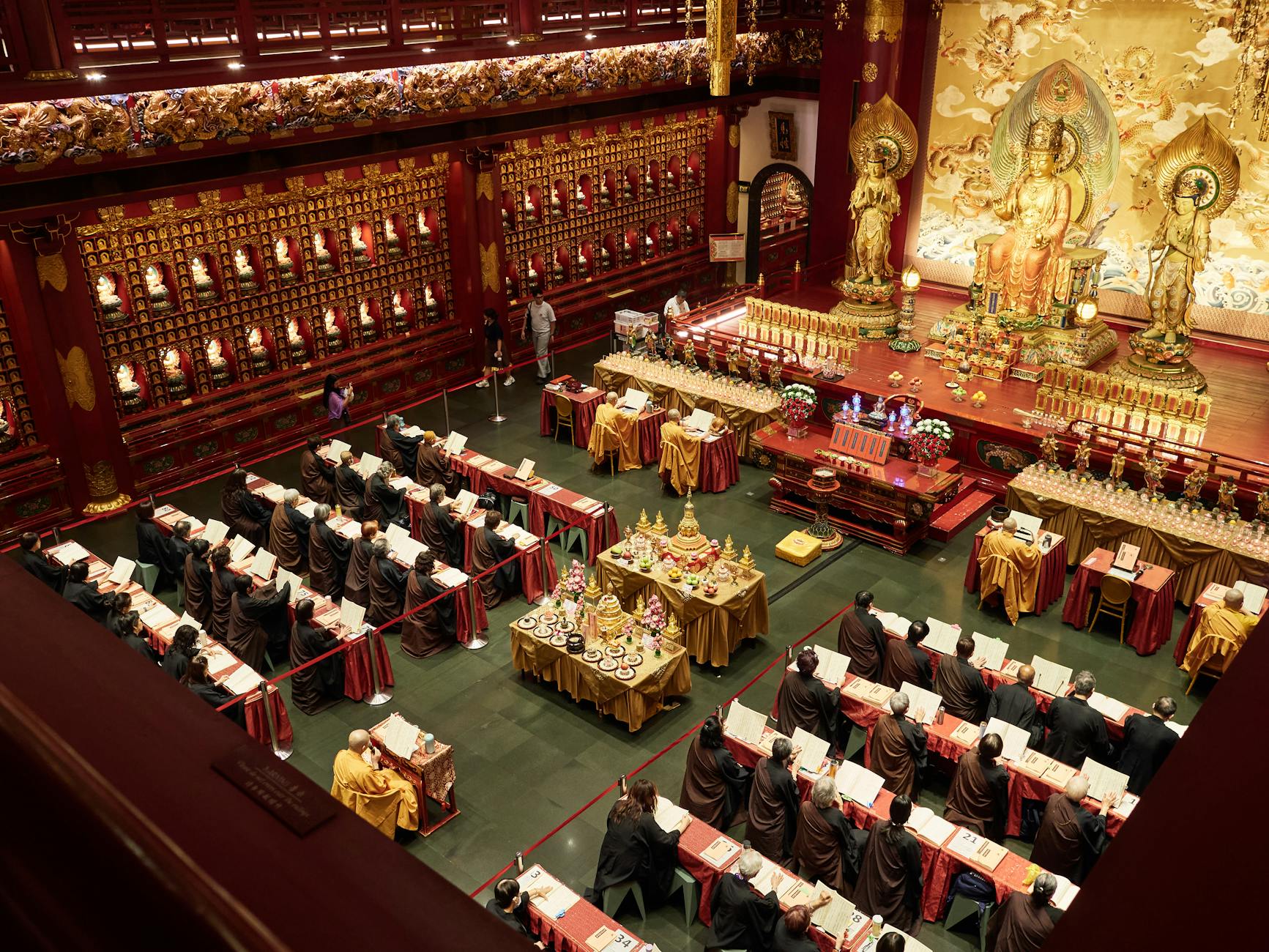A captivating overhead shot of a Buddhist ceremony in a richly decorated temple, filled with monks and vibrant decor.