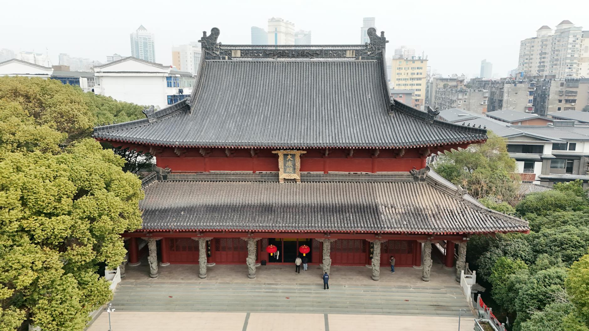 Aerial view of a traditional Chinese temple in Nanchang surrounded by modern cityscape.