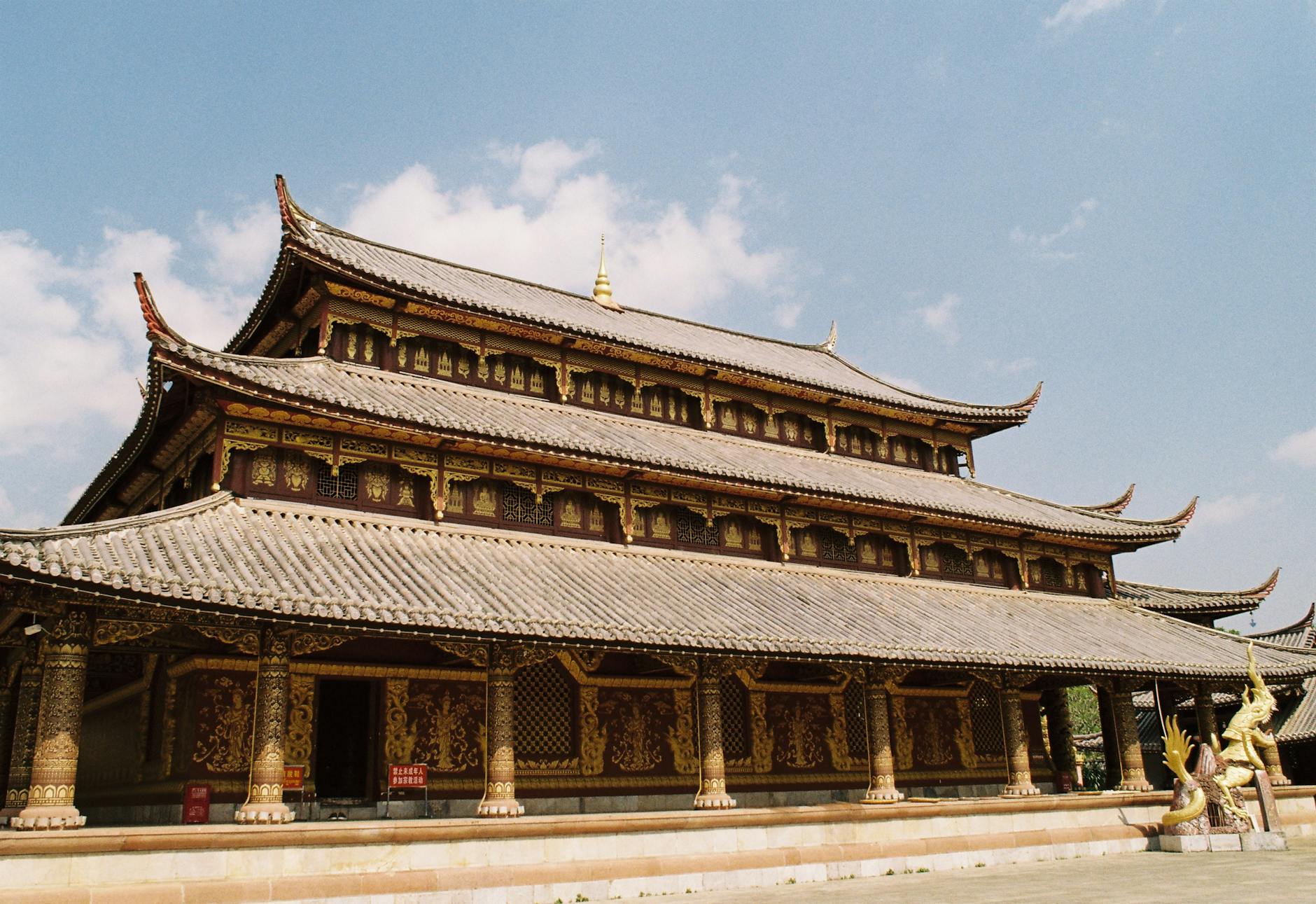 Beautiful traditional Asian temple with intricate architecture under a clear blue sky on a sunny day.