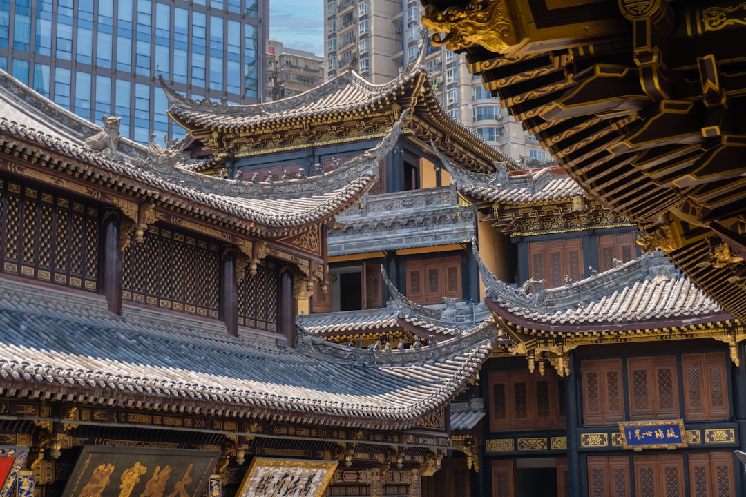 Traditional chinese temple roofs with modern buildings behind.