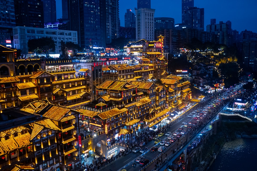 Lively illuminated buildings line a busy street at night.