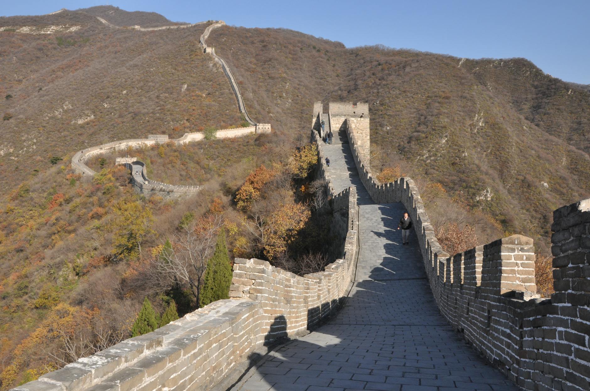 View of the Great Wall of China stretching across rolling hills in autumn.