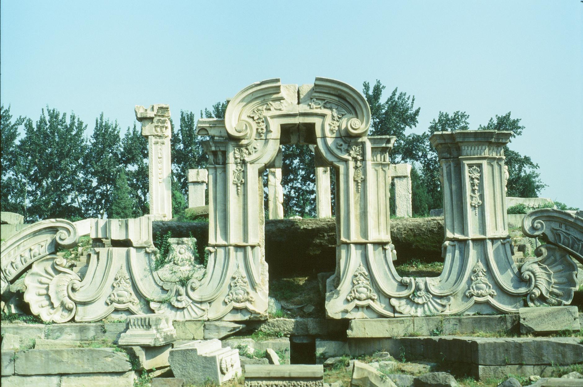 Intricate stone ruins of Yuanmingyuan Garden, Beijing under a clear sky.