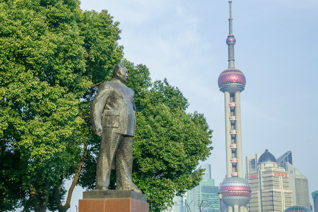 A statue of a man standing in front of a tall building