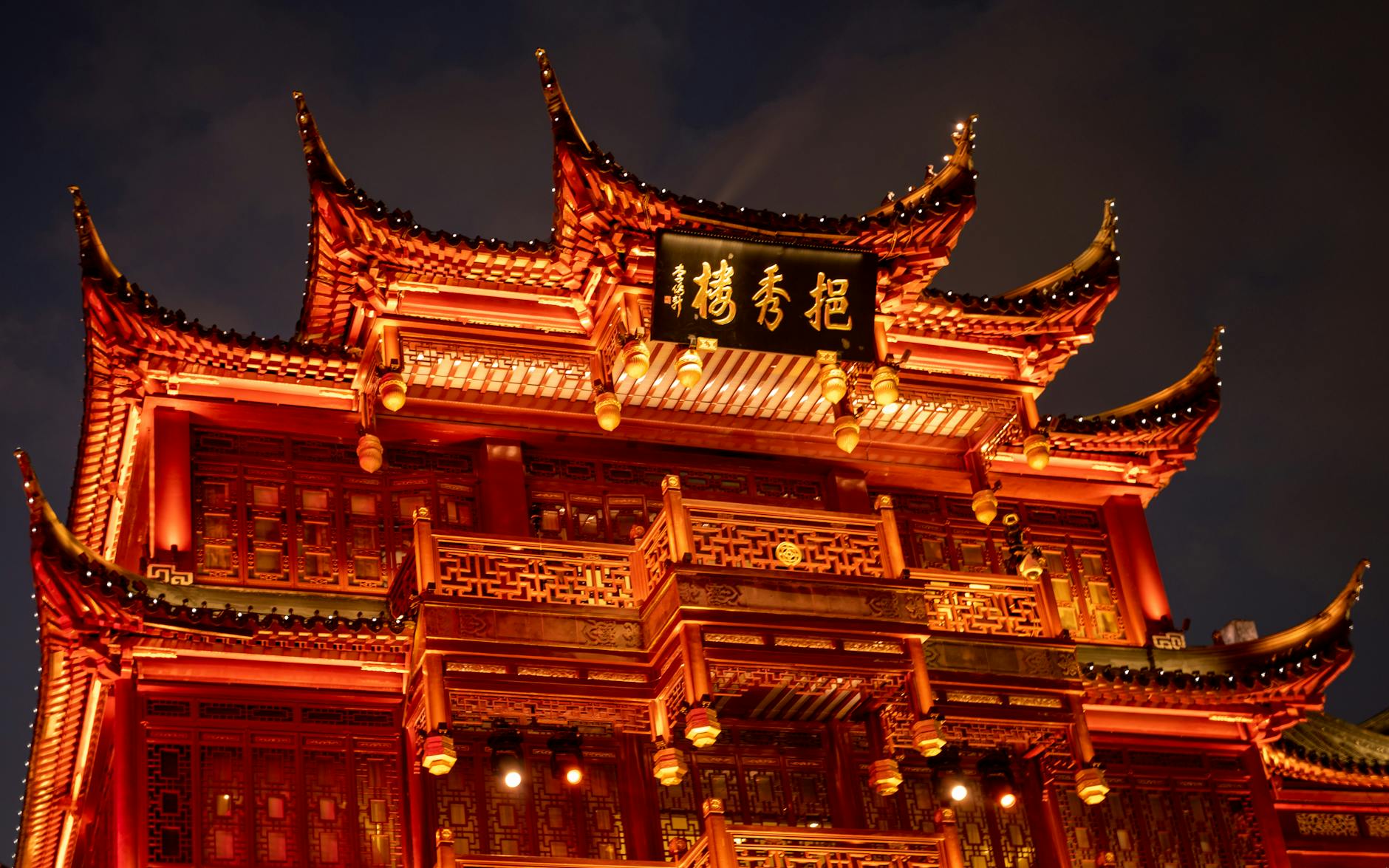 Low angle view of a beautifully lit traditional Chinese building in Shanghai at night.