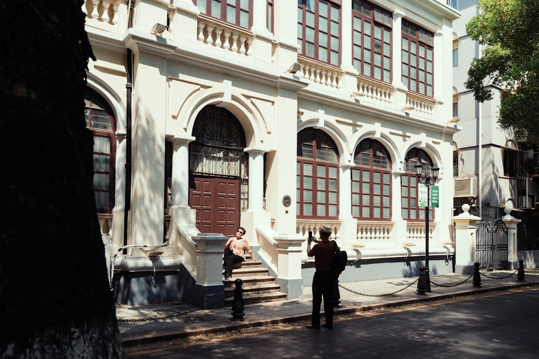 two people standing in front of a white building