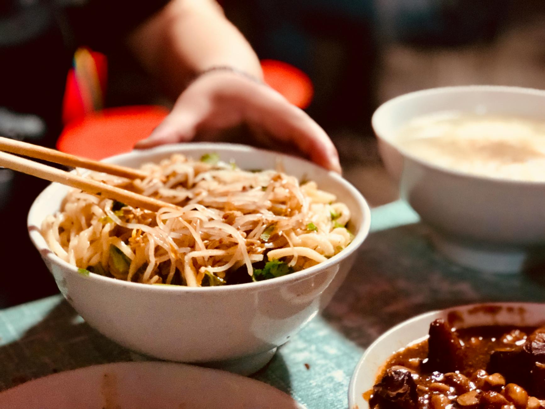 Close-up of a delicious Asian noodle bowl with bean sprouts and chopsticks, highlighting authentic cuisine.