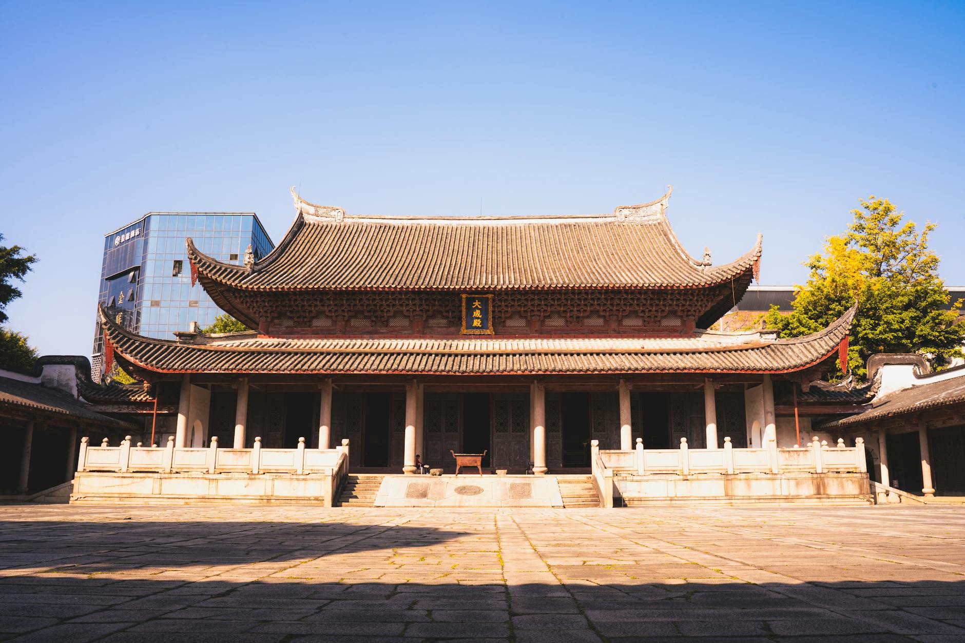Majestic traditional Asian building with intricate roof beneath a clear blue sky, symbolizing cultural heritage.