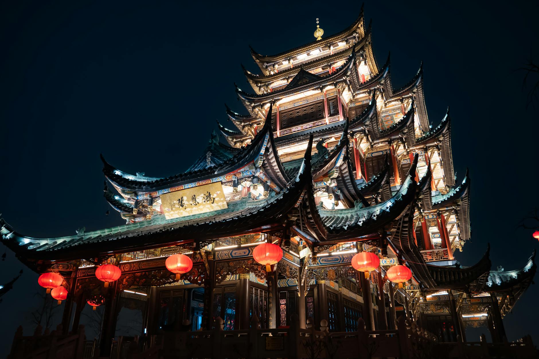 Stunning night view of an illuminated traditional Chinese pagoda in Chongqing, China.