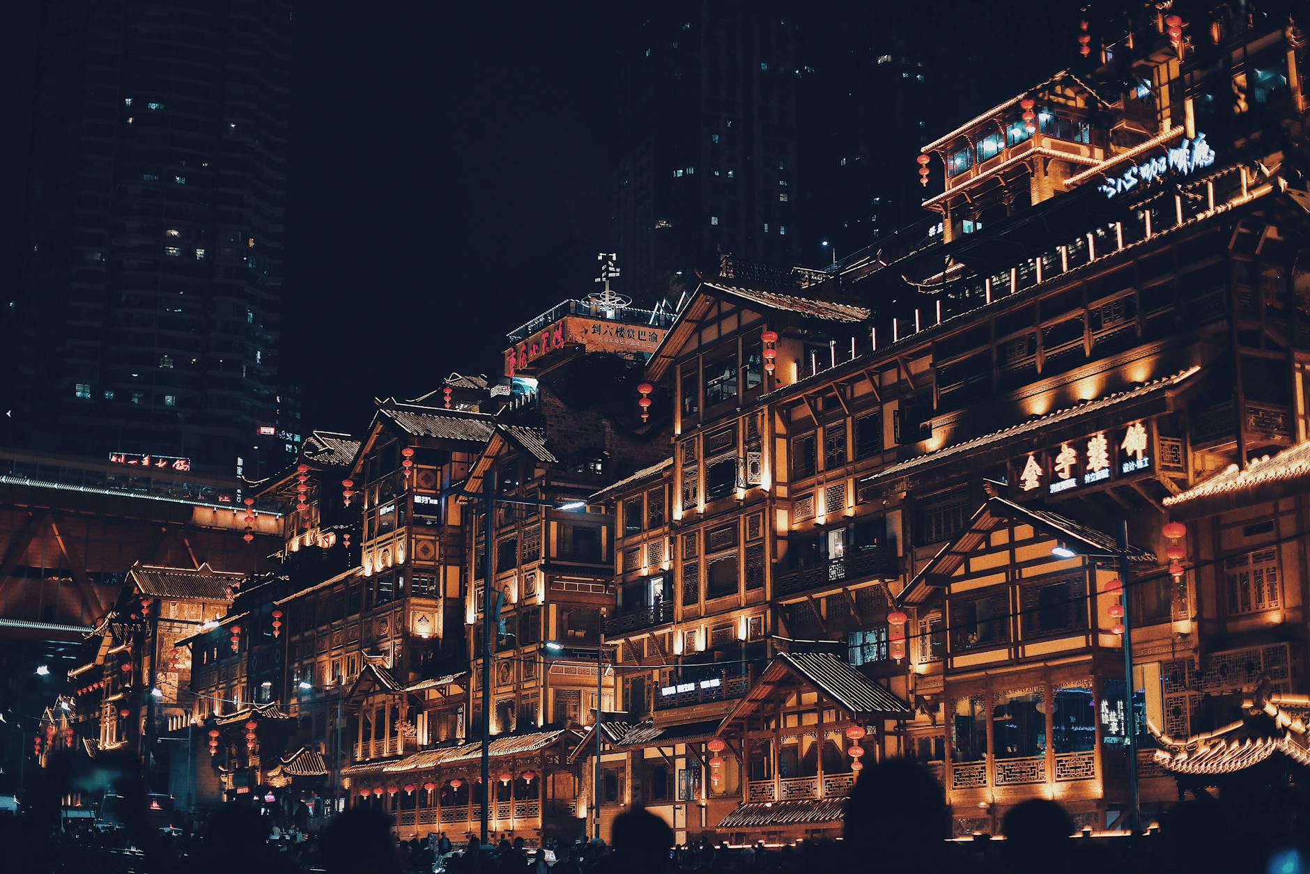 Scenic view of traditional illuminated buildings at night in vibrant urban setting.