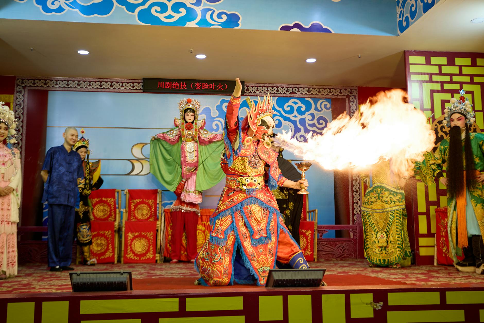 Dramatic Sichuan Opera stage performance featuring colorful costumes and fire-breathing act.