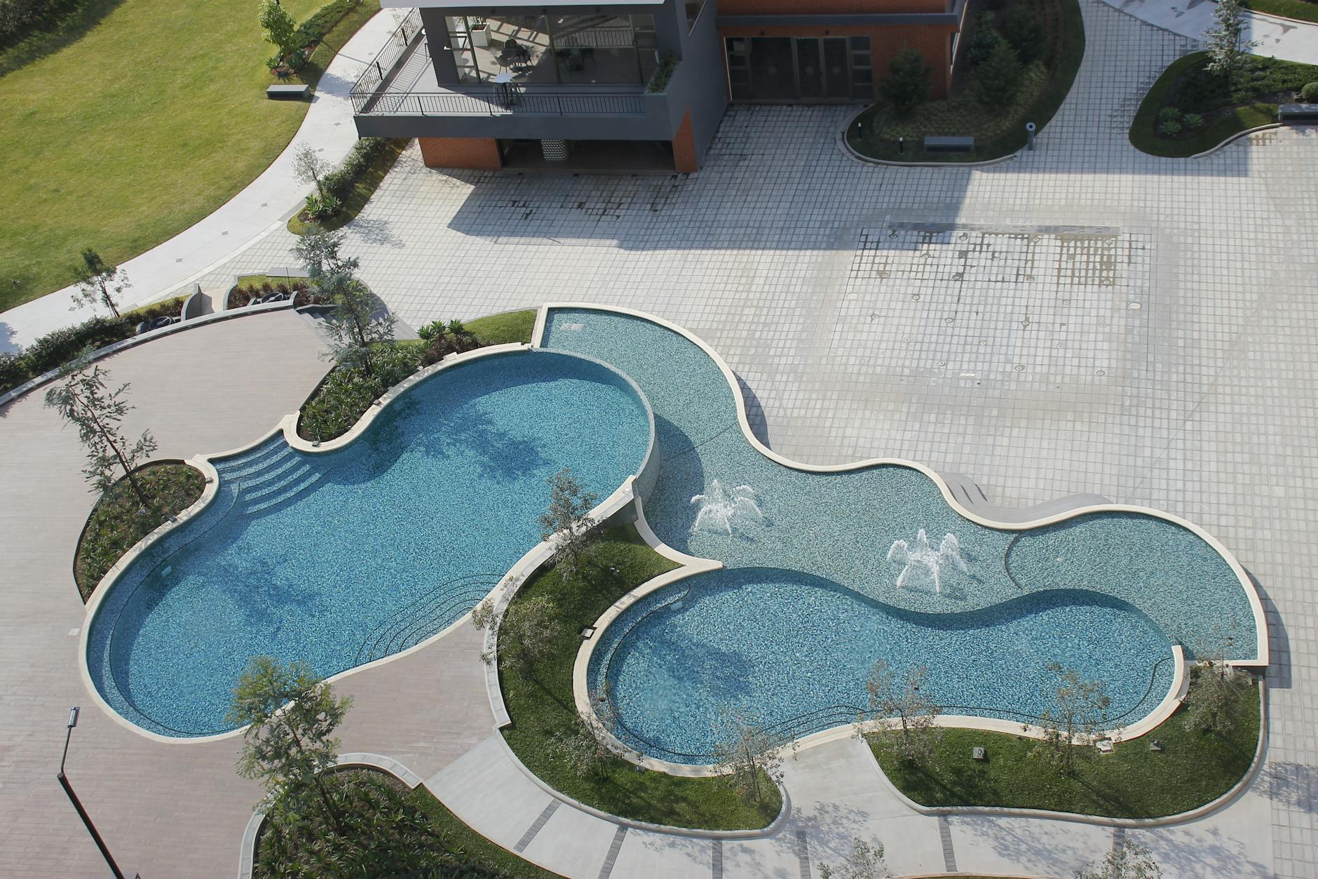 Stunning aerial view of a uniquely shaped modern swimming pool in an outdoor setting.
