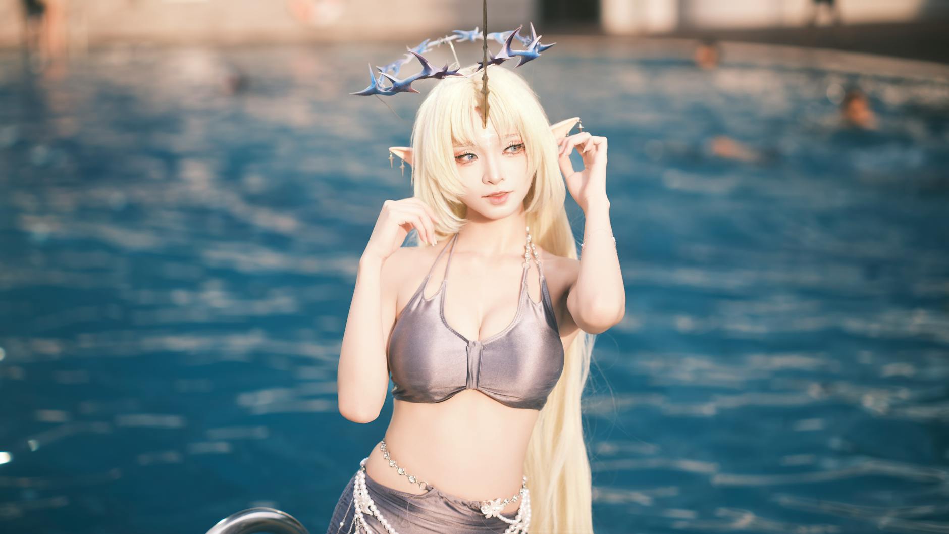 Cosplayer in fantasy attire posing by a swimming pool. Vibrant and artistic.